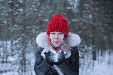 Güzel, çekici, yeşil gözlü, kızıl saçlı, karlı bir ormanda yürüyen bir kız.