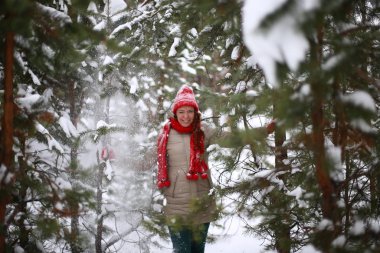 Güzel, çekici, yeşil gözlü, kızıl saçlı, karlı bir ormanda yürüyen bir kız.