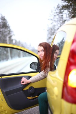 Güzel, çekici, yeşil gözlü, kızıl saçlı, karlı bir ormanda yürüyen bir kız.