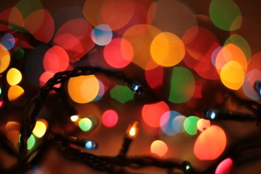 Bir çelengin renkli ışıklarıyla parıldıyor.