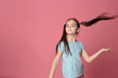 happy smiling girl with two tails long hair in a great cheerful mood on a bright pink background