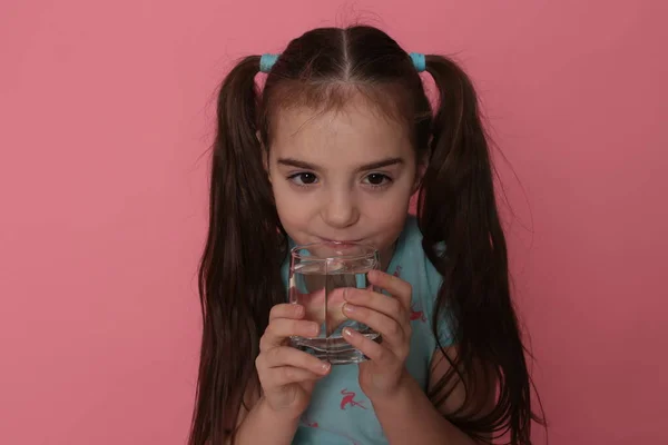 Ένα Όμορφο Κορίτσι Οκτώ Ετών Πίνει Νερό Από Διάφανο Γυαλί — Φωτογραφία Αρχείου