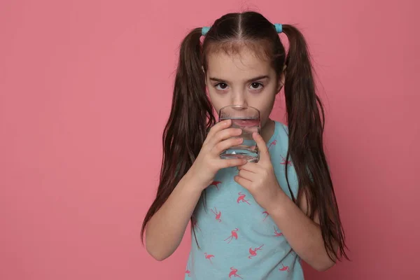 Uma Menina Bonita Oito Anos Bebe Água Vidro Transparente Fundo — Fotografia de Stock