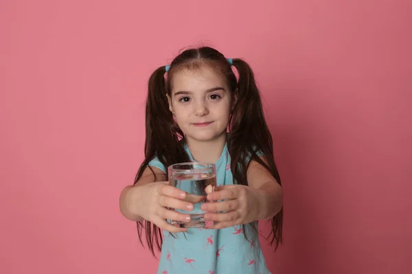 Uma Menina Bonita Oito Anos Bebe Água Vidro Transparente Fundo — Fotografia de Stock