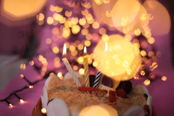 ケーキの中でろうそくを燃やすお祝い明るいピンクの背景誕生日マクロ写真 — ストック写真