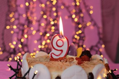 Pasta festivalinde yanan mum. Pembe arka plan. Doğum günü makro fotoğrafı.