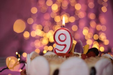 Pasta festivalinde yanan mum. Pembe arka plan. Doğum günü makro fotoğrafı.