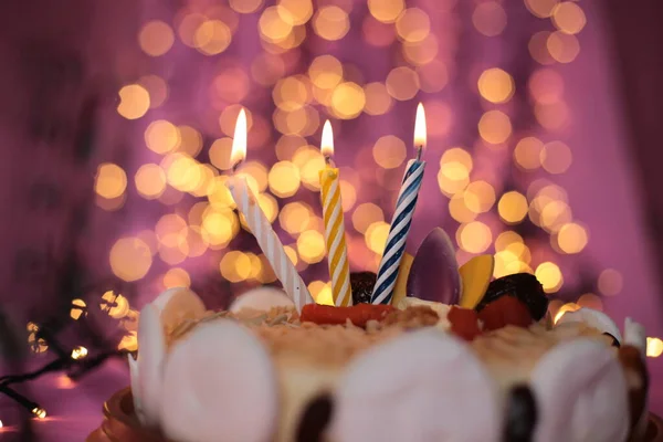 ケーキの中でろうそくを燃やすお祝い明るいピンクの背景誕生日マクロ写真 — ストック写真