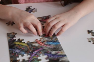 Çocuğun elleri bulmaca toplar. Zeka ve zeka oyunları oynar.