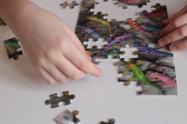 Çocuğun elleri bulmaca toplar. Zeka ve zeka oyunları oynar.