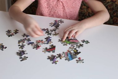 Çocuğun elleri bulmaca toplar. Zeka ve zeka oyunları oynar.