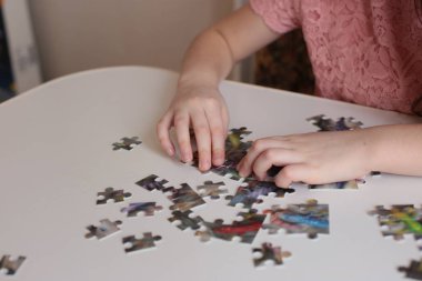 Çocuğun elleri bulmaca toplar. Zeka ve zeka oyunları oynar.