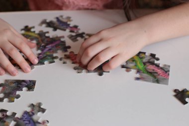 Çocuğun elleri bulmaca toplar. Zeka ve zeka oyunları oynar.
