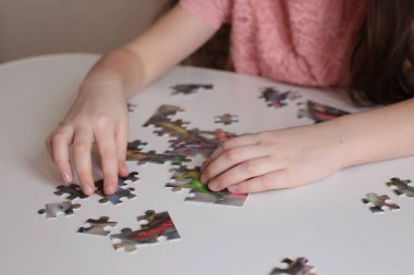 Çocuğun elleri bulmaca toplar. Zeka ve zeka oyunları oynar.