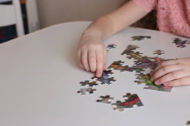 Çocuğun elleri bulmaca toplar. Zeka ve zeka oyunları oynar.