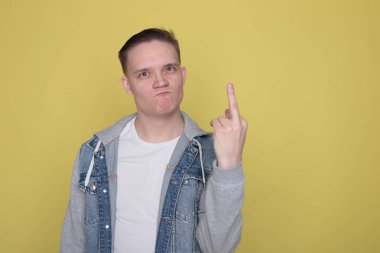 Havalı, havalı, kot giyen, parlak sarı arka planda sıradan giyinen adam.