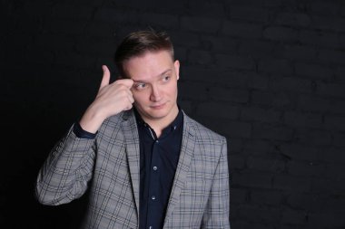 Siyah arka planda ceketli ve gömlekli duygusal bir genç adam portresi.
