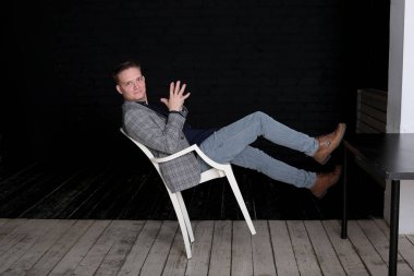 Siyah arka planda ceketli ve gömlekli duygusal bir genç adam portresi.