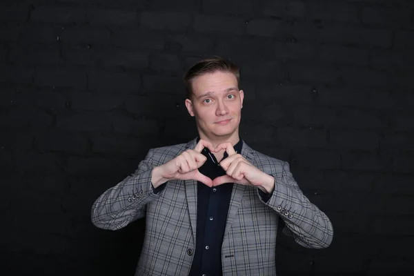 Siyah arka planda ceketli ve gömlekli duygusal bir genç adam portresi.