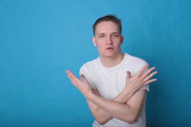 Modern portre duygusal klas, beyaz tişörtlü, parlak mavi arka planlı genç adam.