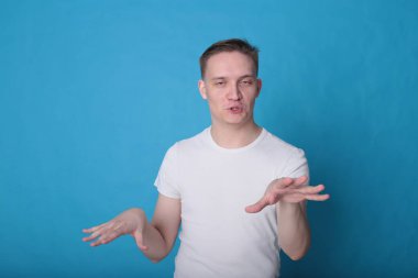 Modern portre duygusal klas, beyaz tişörtlü, parlak mavi arka planlı genç adam.