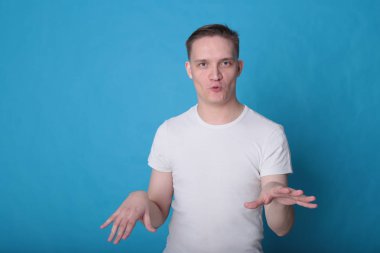 Modern portre duygusal klas, beyaz tişörtlü, parlak mavi arka planlı genç adam.