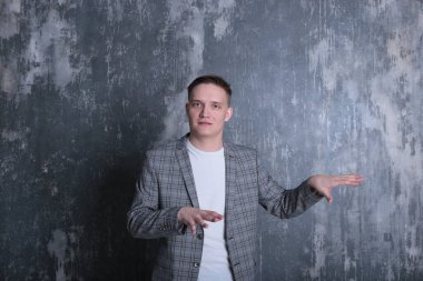 Beyaz tişörtlü ve ceketli şık bir gencin parlak bir arkaplanda ilginç bir portresi.