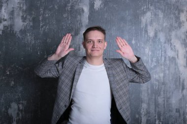 Beyaz tişörtlü ve ceketli şık bir gencin parlak bir arkaplanda ilginç bir portresi.
