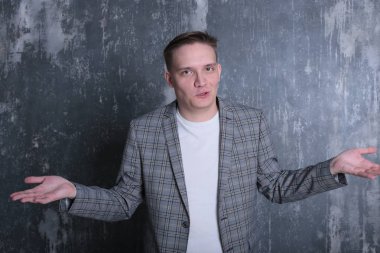 Beyaz tişörtlü ve ceketli şık bir gencin parlak bir arkaplanda ilginç bir portresi.