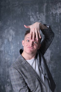 Beyaz tişörtlü ve ceketli şık bir gencin parlak bir arkaplanda ilginç bir portresi.