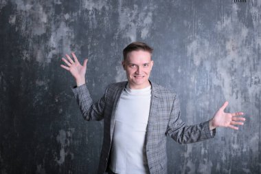 Beyaz tişörtlü ve ceketli şık bir gencin parlak bir arkaplanda ilginç bir portresi.