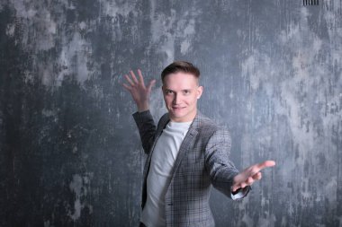 Beyaz tişörtlü ve ceketli şık bir gencin parlak bir arkaplanda ilginç bir portresi.