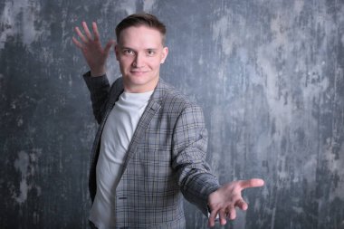 Beyaz tişörtlü ve ceketli şık bir gencin parlak bir arkaplanda ilginç bir portresi.