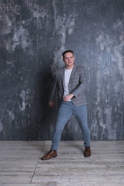 Beyaz tişörtlü ve ceketli şık bir gencin parlak bir arkaplanda ilginç bir portresi.