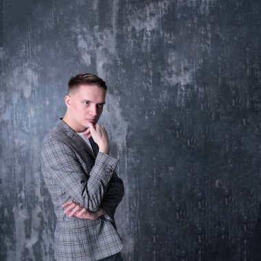 Beyaz tişörtlü ve ceketli şık bir gencin parlak bir arkaplanda ilginç bir portresi.