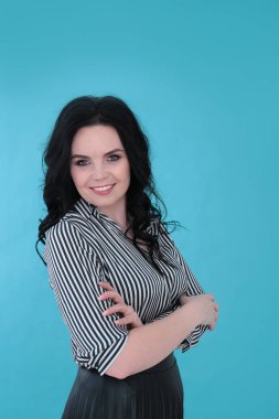 Parlak turkuaz arka planda çizgili bluzu ve pileli eteği olan güzel genç bir kadın.