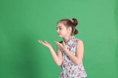 Gülümseyen, sekiz yaşında güzel bir kız. Mükemmel bir ruh hali içinde. Mavi bluzlu, çiçekli komik bir saç stili var.