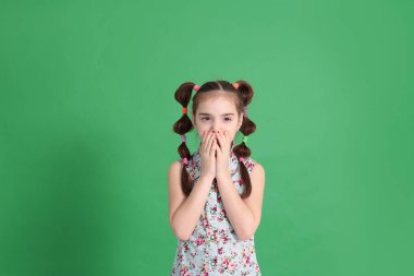 Gülümseyen, sekiz yaşında güzel bir kız. Mükemmel bir ruh hali içinde. Mavi bluzlu, çiçekli komik bir saç stili var.