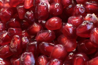 Sulu, olgun nar tohumlarının Macro fotoğrafı, parlak bordo yemek arkaplanı.