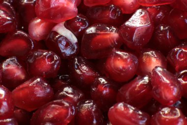 Sulu, olgun nar tohumlarının Macro fotoğrafı, parlak bordo yemek arkaplanı.