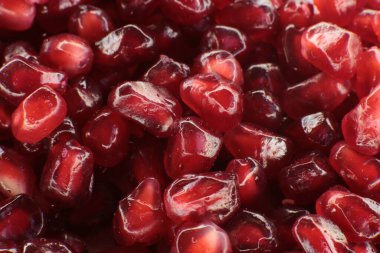 Sulu, olgun nar tohumlarının Macro fotoğrafı, parlak bordo yemek arkaplanı.