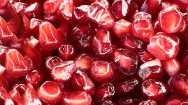 Sulu, olgun nar tohumlarının Macro fotoğrafı, parlak bordo yemek arkaplanı.