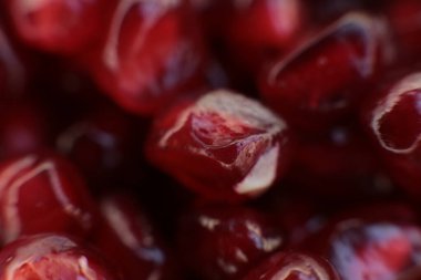 Sulu, olgun nar tohumlarının Macro fotoğrafı, parlak bordo yemek arkaplanı.