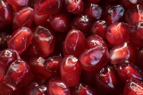 Sulu, olgun nar tohumlarının Macro fotoğrafı, parlak bordo yemek arkaplanı.