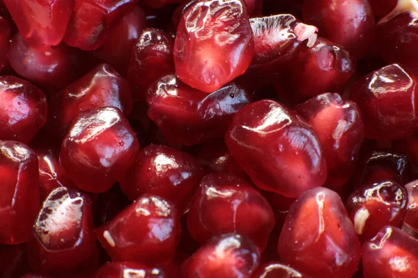 Sulu, olgun nar tohumlarının Macro fotoğrafı, parlak bordo yemek arkaplanı.