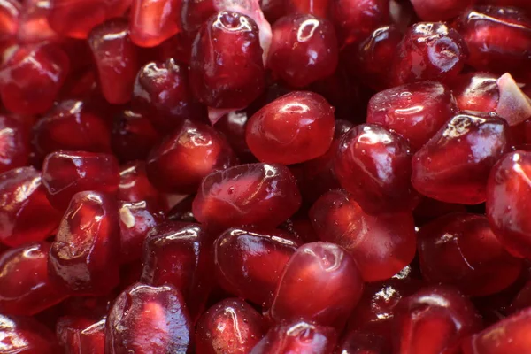 Sulu, olgun nar tohumlarının Macro fotoğrafı, parlak bordo yemek arkaplanı.