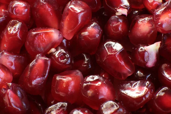 Sulu, olgun nar tohumlarının Macro fotoğrafı, parlak bordo yemek arkaplanı.