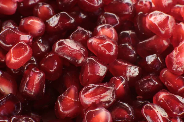 Sulu, olgun nar tohumlarının Macro fotoğrafı, parlak bordo yemek arkaplanı.