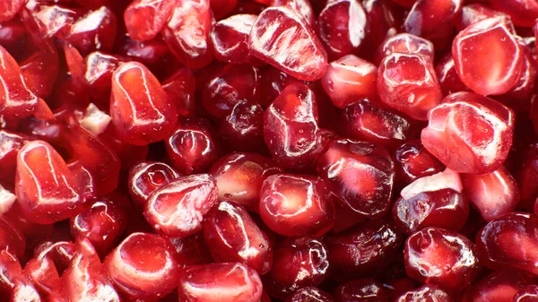 Sulu, olgun nar tohumlarının Macro fotoğrafı, parlak bordo yemek arkaplanı.