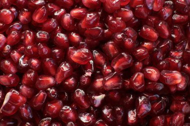 Sulu, olgun nar tohumlarının Macro fotoğrafı, parlak bordo yemek arkaplanı.